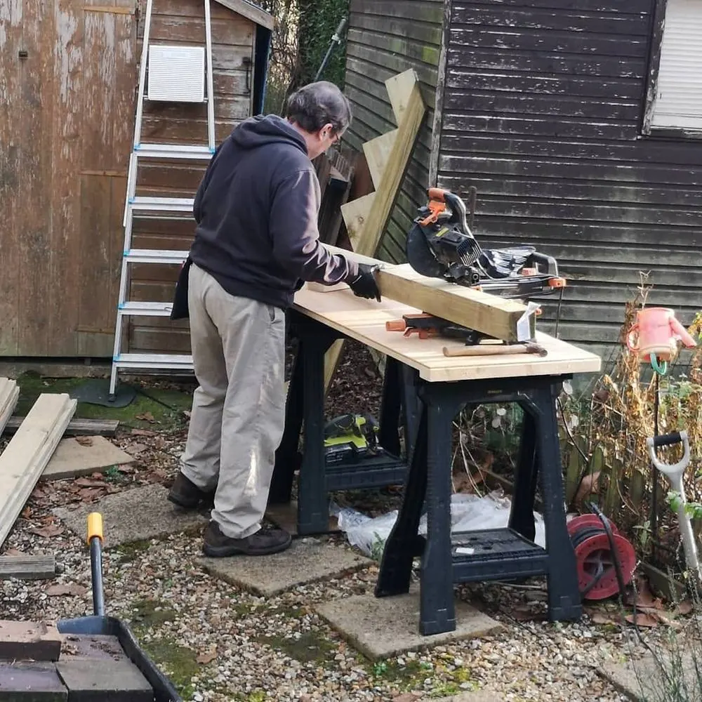 Sean cutting timber on a mitre saw on site